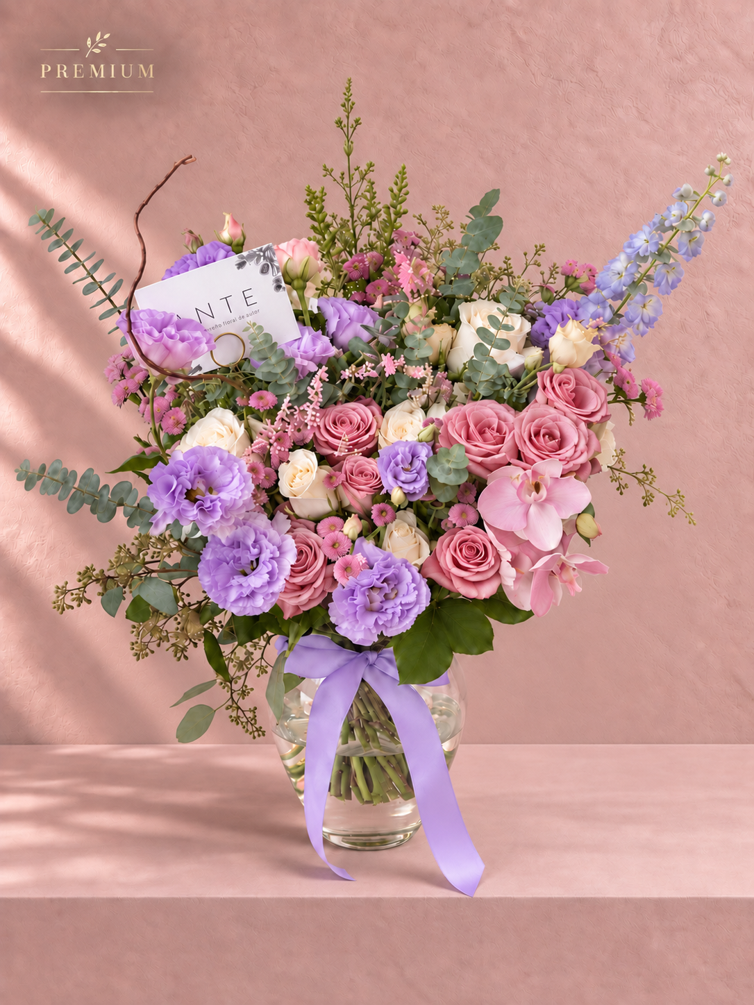 Arreglo floral premium con lisianthus morado, rosas rosas y orquídea rosa en florero de vidrio con moño lila, entrega a domicilio CDMX