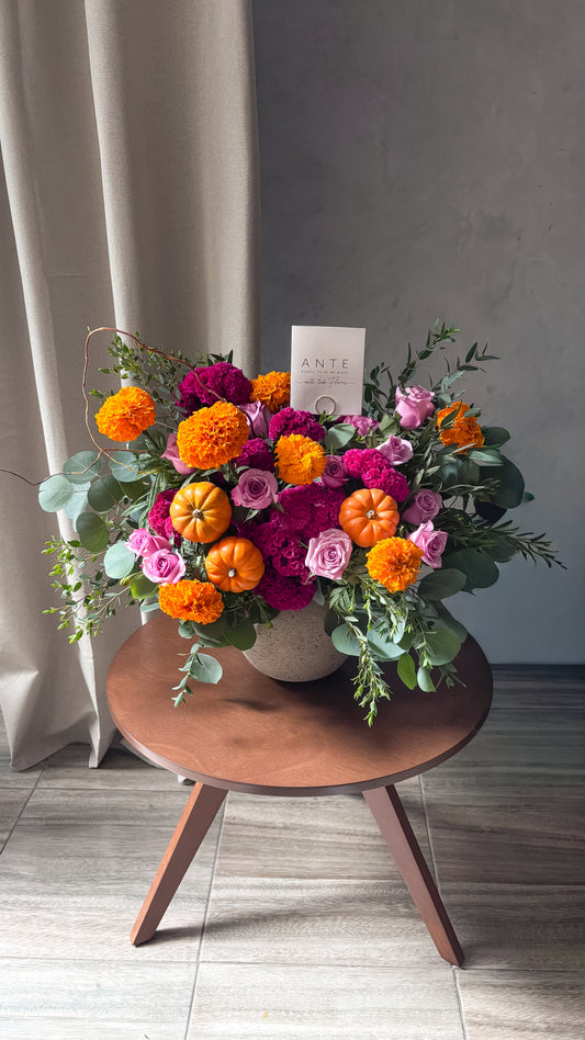 Arreglo de cempasúchil, cresta de gallo fucsia, rosas lila y mini calabazas en florero cerámico gris para Día de Muertos, entrega a domicilio CDMX
