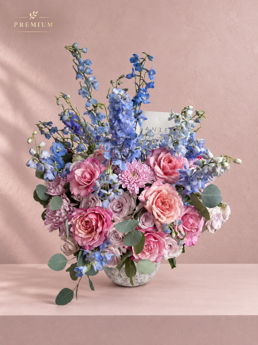 Arreglo floral con delphinium azul, rosas rosa y durazno, y crisantemo malva en florero cerámico, entrega a domicilio CDMX