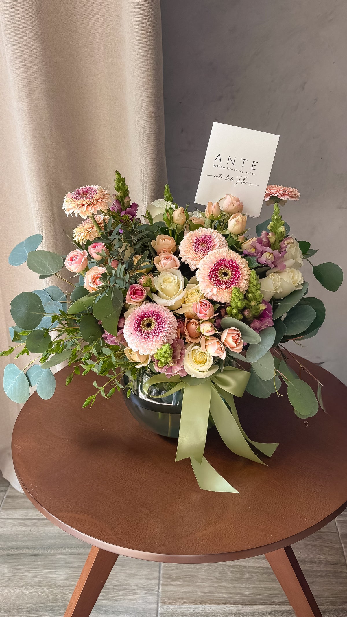Arreglo floral con gerberas blancas, rosas durazno y rosas rosa en florero de vidrio con moño celeste, entrega a domicilio CDMX