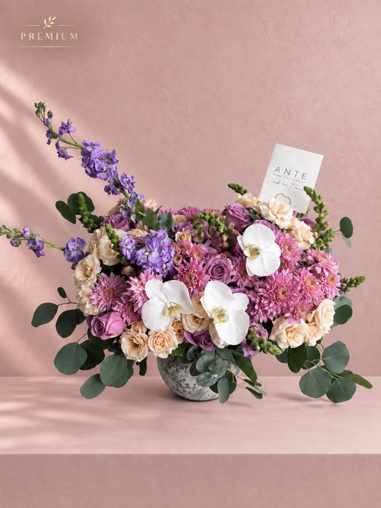 Arreglo floral con orquídeas blancas y rosas moradas en florero cerámico, entrega a domicilio CDMX