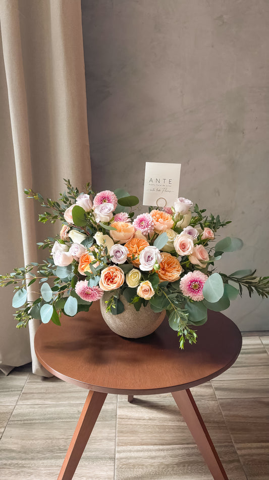 Arreglo floral con rosas inglesas juliet, rosas blancas, mini rosas lila y durazno, y gerbera rosa en florero cerámico, entrega a domicilio CDMX