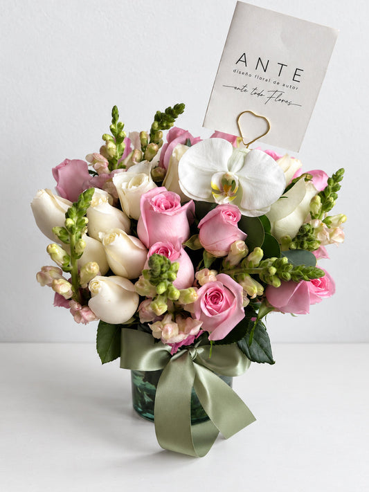 
Ramo de rosas rosas y blancas con alhelí lila en florero de vidrio con moño verde salvia,